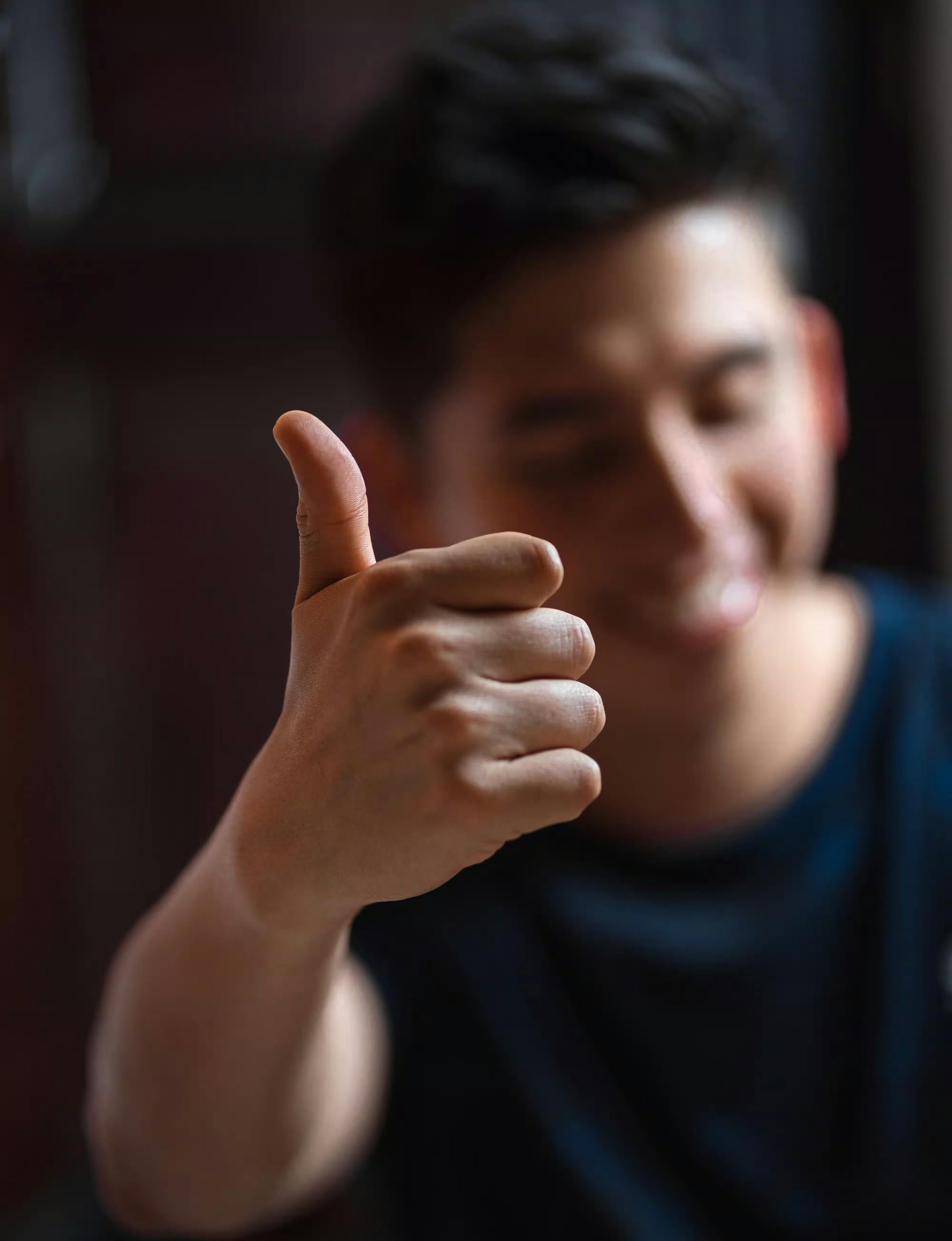 Smiling man holding out his hand with his thumb up
