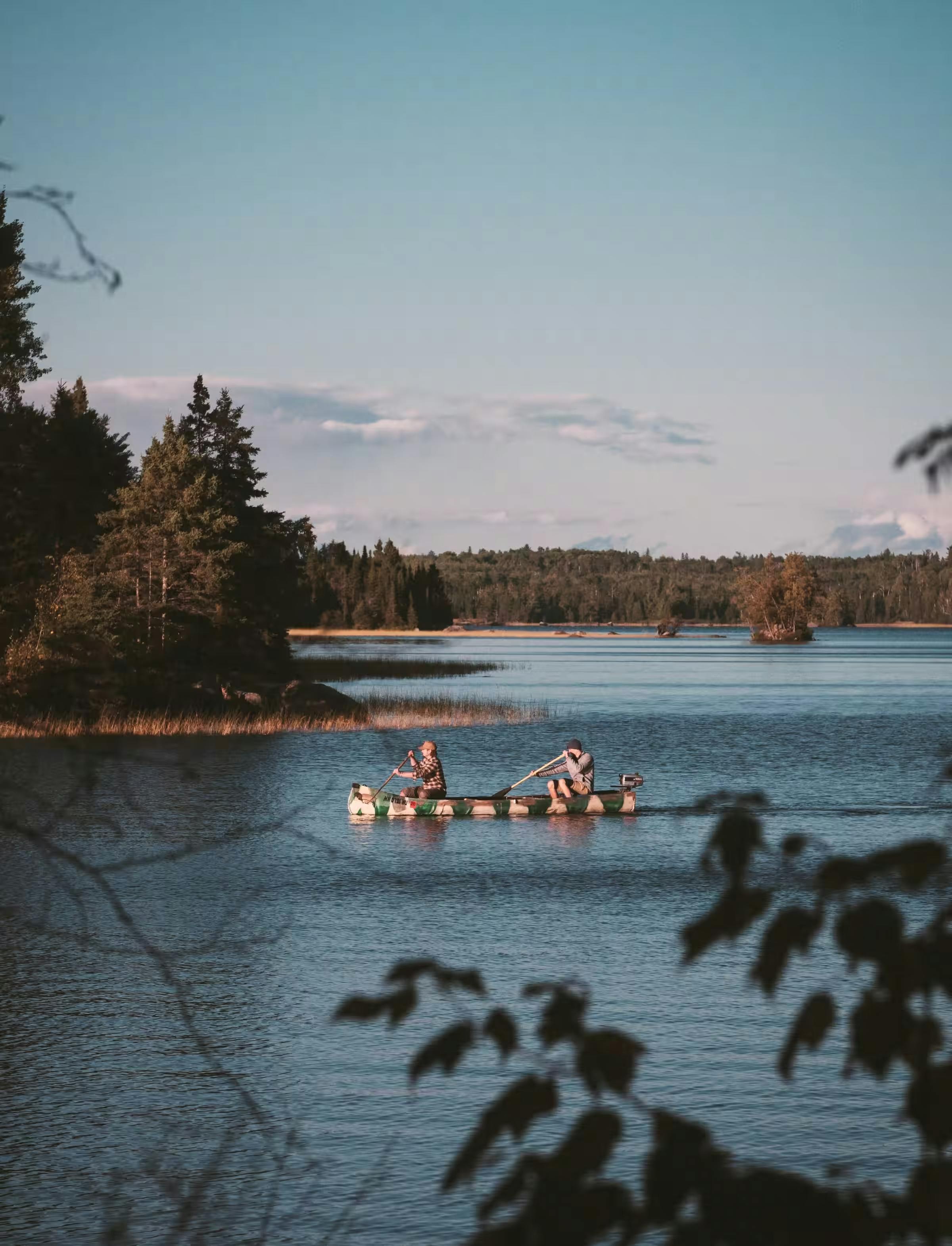 Two people paddling in a boat on a lake
